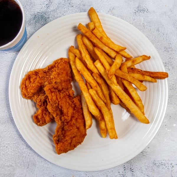 Crispy fried chicken tenders and golden french fries on a white plate with a drink.