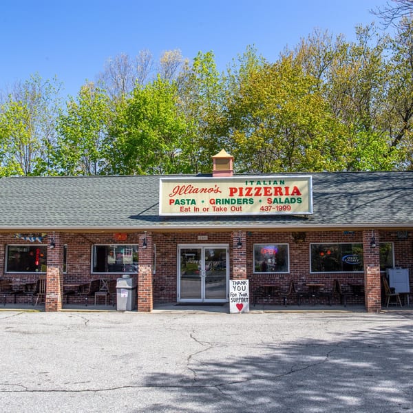 Illiano's Pizzeria, a brick building with a sign advertising Italian food, pasta, grinders, and salads.