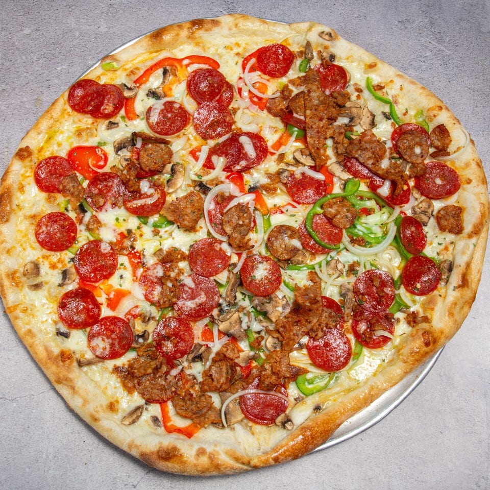 A large, round pizza with pepperoni, sausage, mushrooms, onions, and bell peppers.